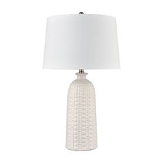 a white table lamp with a white shade on the base and a white fabric lampshade