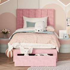 a pink bed with pillows and blankets on top of it next to a white rug