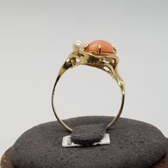 Vintage 14K Yellow Gold with Coral, Pearl and Mother of Pearl Ring, Size 7.5. Stamped 14K A&E inside band. Coral and MOP are 12 x 6mm, pearls are 3mm. Ring is 24mm wide. Weighs 2.5 dwt. We do not check prongs for wear or stones for looseness.  All items are sold as is-noting that we are a resale shop  so everything here had a previous owner! We will include flaws in the description when noted. This is one of the reasons our items are more affordable than new at a jewelry store. Are these stones real or fake? Aside from diamonds, we do not know if any gemstones are natural or synthetic. We will state on certain gemstones, that we know 100%, if they are created or fake due to their lack of inclusions. For this reason, we do not sell any diamonds without inclusions, and the larger diamonds (h Collectible 14k Gold Multi-stone Rings, Collectible Multi-stone 14k Gold Rings, White Gold Cabochon Rings In 14k Gold, 14k White Gold Cabochon Rings, White Gold Cabochon 14k Gold Rings, White Gold Cabochon Rings 14k, 14k Yellow Gold Opal Ring For Anniversary, Anniversary 14k Gold Opal Ring, 14k Gold Cabochon Ring With Round Band