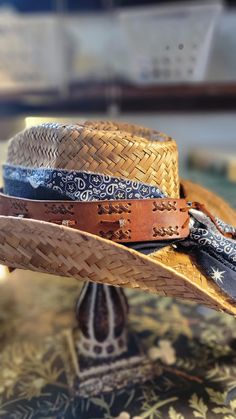 Turn heads in this unique cocoa straw cowboy hat! Featuring a distressed vintage leather hatband adorned with shimmering silver beads, a bold buffalo nickel concho, and playful tail feathers, this hat is a true statement piece. Crafted with high-quality materials and designed for ultimate comfort, it's perfect for festivals, rodeos, or any adventure. Adjustable to fit most head sizes, this hat is a must-have for the modern-day cowboy or cowgirl. Rustic Adjustable Hats For Rodeo, Country Style Concho Hat Band For Rodeo, Distressed Adjustable Hats For Country Events, Adjustable Distressed Hats For Country Events, Western Brown Straw Hat For Ranch, Brown Western Straw Hat For Ranch, Western Brown Hat Bands For Rodeo, Brown Country Hat Bands For Rodeo, Rustic Brown Hat Bands For Rodeo