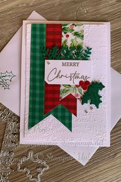 a christmas card with holly and mist on it, sitting next to some paper work