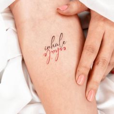 a woman's legs with the word inhale joy written on her left leg