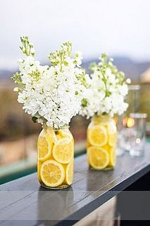 three mason jars filled with lemons and white flowers