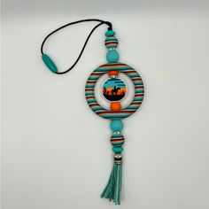 a necklace with an orange and blue bead hanging from it's center circle