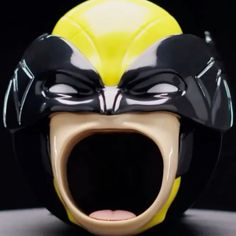 a yellow and black mask with its mouth open