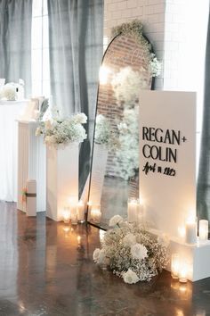 a wedding ceremony with candles and flowers on the floor in front of a large mirror