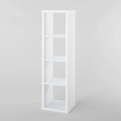 a white bookcase with three shelves on the bottom and one shelf in the middle