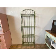 a green metal shelf next to a pink dresser