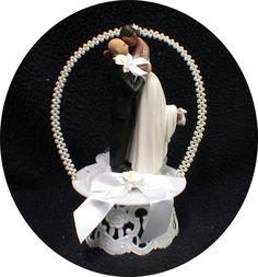 a bride and groom figurine on top of a cake with pearls around it