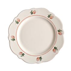 a white plate with pink flowers and green leaves on the rim, against a white background