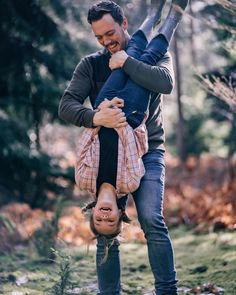 a man is holding onto the back of a woman's head while she holds her upside down