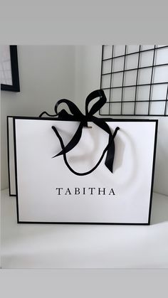 a white bag with a black ribbon tied around it