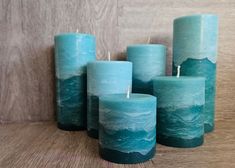 five teal colored candles sitting next to each other