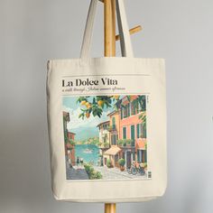 ♥ Evoke the Italian summer with our La Dolce Vita Lemon Print Canvas Tote Bag. Made for beach days and leisurely strolls, this aesthetic essential adds a touch of Mediterranean charm to your summer vibes.  ♥ Carry your essentials in style and embrace the sweet life of summer.  ♥ Gift-worthy: Makes a delightful present for anyone seeking a taste of Italian elegance ♥ This 100% cotton bag comes in one size - 15" x 16" ♥ The bag features 20" handles (made from the same canvas), making it easy to ca Casual Spring Shoulder Bag With Letter Print, Trendy Spring Canvas Bag With Letter Print, Casual Spring Vacation Canvas Bag, Trendy Letter Print Canvas Bag For Spring, Casual Letter Print Bag For Spring, Large Capacity Summer Canvas Bag, Casual Summer Canvas Shoulder Bag, Large Capacity Canvas Bag For Summer, Casual Canvas Shoulder Bag For Summer