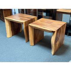 two wooden tables sitting on top of a blue carpeted floor