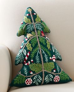 a green christmas tree pillow sitting on top of a white couch