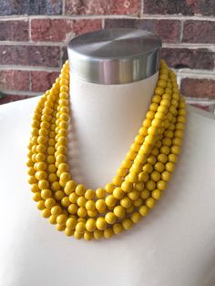 A fun beaded multi strand statement necklace made with dark yellow acrylic beads. This necklace is perfect for dressing up a casual outfit or wearing for a special occasion. - 6 strands (more options are listed)- Shortest strand measures 18.5 - 20.5" long (will vary depending on the clasp)- Lobster claw clasp is stainless steel (gold filled, sterling silver, and gold stainless steel are also available) - Multi strand connector is lead free pewter- 2" stainless steel extender chain- Beads measure Yellow Multi-strand Polished Beaded Necklaces, Pearl Statement Necklace, Silver Jewelry Box, Long Beaded Necklace, Brooch Necklace, Beaded Statement Necklace, Gold Gift, Mens Beaded Bracelets, Dark Yellow