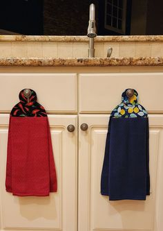 two towels are hanging on the kitchen cabinets