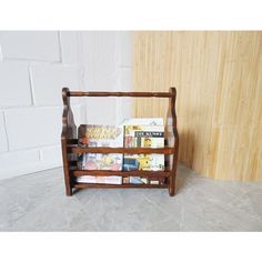 a wooden shelf with books on it next to a brick wall