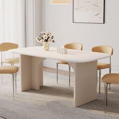 a white table with four chairs around it and a vase filled with flowers on top