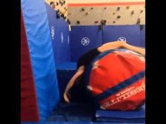 a person is laying on top of a ball in a gym area with blue walls