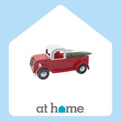 a red truck with a christmas tree in the back and at home logo on it