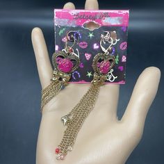 Vintage Y2k Betsy Johnson Betsyville Gold Tone Pink Rose, Heart And Bow With Dangle Chain Fringe Earrings. These Would Make A Great Valentine’s Day Gift To Yourself As The Earrings Are In New Condition However, The Backboard That It Is Attached To Shows Signs Of Wear, But They Are Still Nwt Trendy Dangle Heart Earrings For Valentine's Day, Trendy Party Heart Earrings With Heart Charm, Trendy Gold Heart Earrings For Party, Trendy Metal Heart Earrings For Party, Trendy Party Heart Earrings, Trendy Heart Earrings For Party, Trendy Dangling Charms Earrings For Party, Chain Fringe, Rose Heart