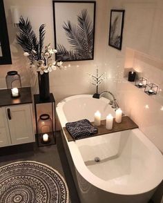 a white bath tub sitting next to a bathroom sink with candles on top of it