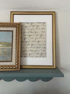 two framed pictures are sitting on a shelf next to each other, one with writing and the other without