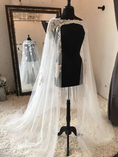 a mannequin with a wedding dress and veil on it in front of a mirror