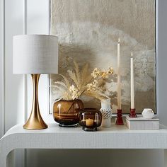 a white table topped with candles and vases