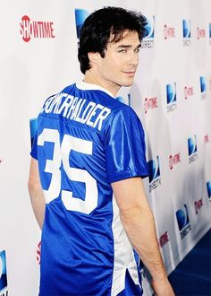 a black and white photo of a man in a football jersey on the red carpet