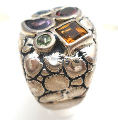 Designer Jewelry - This is a substantial sterling silver croco ring by Falchi with multi color gemstones of amethyst, garnet, citrine, blue topaz and peridot. The ring is a size 5, signed with maker's mark CHI for Falchi, hallmarked 925, measures .75" wide and weighs 13.8 grams. Multicolor Multi-stone Amethyst Ring In Sterling Silver, Unique Multi-stone Amethyst Ring In Sterling Silver, Maker's Mark, Designer Jewelry, Makers Mark, Blue Topaz, Citrine, Garnet, Topaz