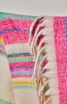 a multicolored blanket with fringes on it