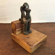 a wooden block with a metal sculpture on top of it