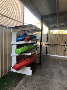 several kayaks are lined up against the wall