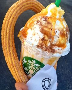 a person holding up a starbucks drink with caramel and whipped cream in it's cup