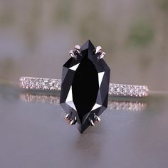 a black diamond ring sitting on top of a table