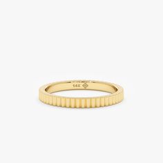 a yellow gold ring with thin lines on it