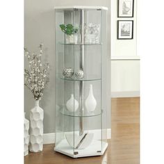 a glass display case sitting on top of a hard wood floor next to a vase