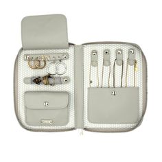 an open case with various items in it on a white background, including rings and bracelets