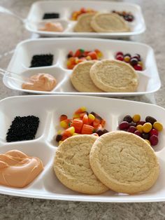 three white trays filled with cookies and candy