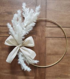 a headband with white feathers and a bow on top of a wooden floor next to a circle