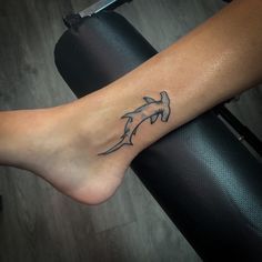 a person with a tattoo on their foot that has two dolphins in the middle of it