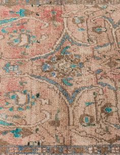 an old rug with many different colors and patterns on the carpet, including blue, pink, green, orange, and beige