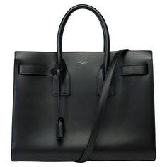 "Saint-Laurent"​ ​Sac​ ​de​ ​Jour​ ​Small​ ​handbag​ ​strap​ ​in​ ​black​ ​smooth​ ​box​ ​calf​ ​leather,​ ​blackened​ ​metal​ ​trim,​ ​decorated​ ​with​ ​side​ ​bellows,​ ​compression​ ​straps​ ​with​ ​legs​ ​and​ ​a​ ​removable​ ​and​ ​adjustable​ ​shoulder​ ​strap​ ​for​ ​hand​ ​or​ ​shoulder​ ​carry Leather​ ​lining Padlock​ ​in​ ​a​ ​removable​ ​leather​ ​case Removable​ ​central​ ​case​ ​with​ ​zip​ ​closure​ ​ Signature:​ ​"Saint​ ​Laurent​ ​Paris"​ ​ Dimensions:​ ​32x26x15cm​ ​(12,5x10,2 Baggage Claim, Small Handbag, Saint Laurent Paris, Metal Trim, Handbag Straps, Black Box, Small Handbags, Birkin Bag, Gucci Jackie Bag