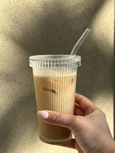 a person holding a cup with a straw in it