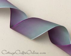 a purple ribbon on a white surface