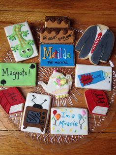 decorated cookies on a glass platter with magnets in the shape of people's names