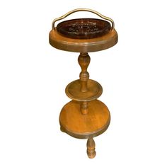 an antique wooden table with three tiered trays on each side and a metal handle at the top